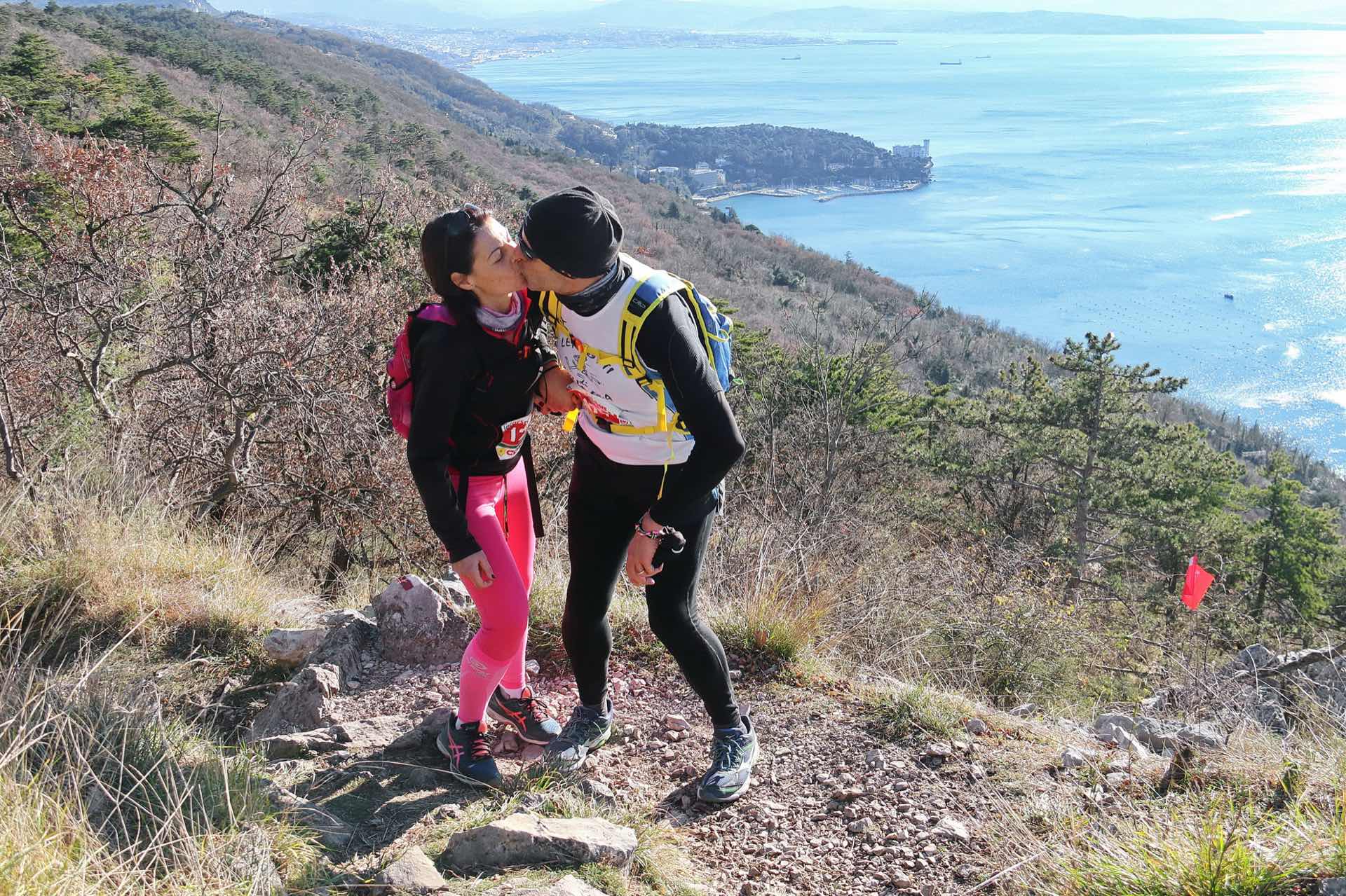 Due concorrenti della Corsa della Bora si scambiano un bacio di corsa a Santa Croce